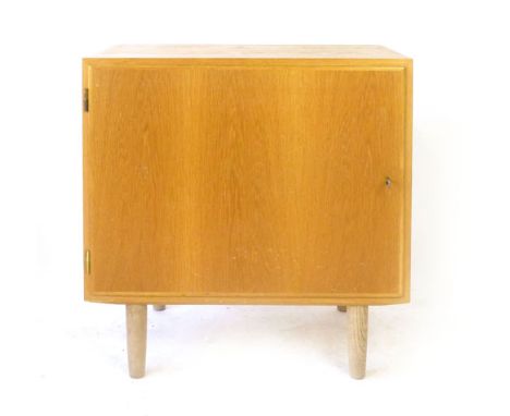 A 1960/70's oak single door cabinet on circular tapering feet, by Poul Hundevad, w. 70 cm
 CONDITION REPORT: Structurally sou