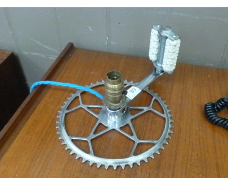 A table lamp in the form of a converted bicycle cog and pedal
 CONDITION REPORT: Working order unknown