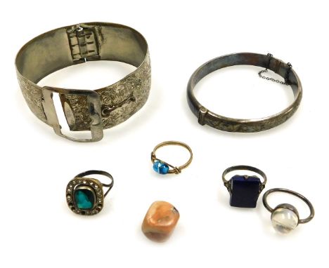 A group of costume jewellery, comprising a silver hinged bangle, three dress rings, each of Deco design set with lapis style 