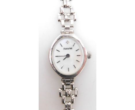 An Accurist 9ct white gold lady's wristwatch, with oval silvered colour dial set with tiny diamond, on a fancy gate style bra