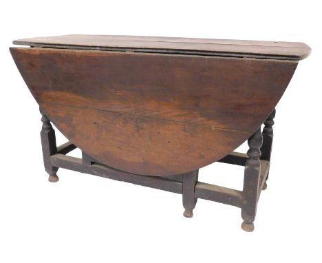 A 17thC oak gate leg table, with oval drop leaf top, baluster turned and square framed legs, with plain stretchers and turned