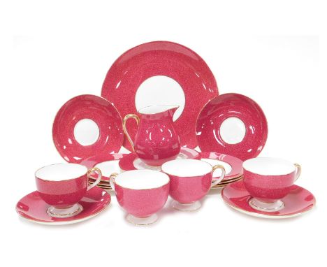 An early 20thC Wedgewood porcelain part tea service, decorated on a powder red ground, with gilt edging, comprising cream jug