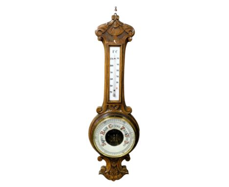 A Victorian oak cased aneroid barometer, with thermometer, the case with carved decoration, 81cm high.
