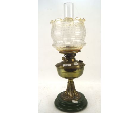 A Victorian oil lamp, the brass frame and reservoir mounted on a ceramic base with a textured glass shade, (excluding funnel)