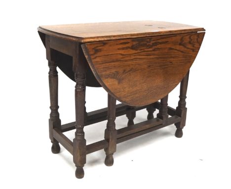 An early 20th century oak drop leaf gate leg table, raised upon turned supports, L89cm x D46cm x H71cm when folded