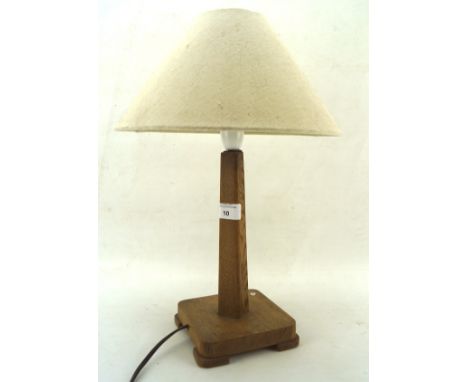 An early 20th century oak table lamp, with tapered upright on a squared stand raised on four corner feet, H26.5cm to fitting,