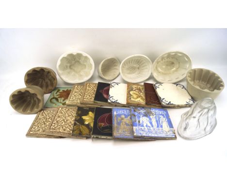 An assortment of ceramic tiles and jelly moulds, the tiles including two early 20th century blue and white examples, tiles ci