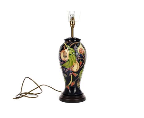 CONTEMPORARY MOORCROFT TABLE LAMP, of baluster form, tube-lined with fruiting foliage on a dark blue ground, raised on a hard