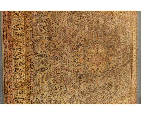 Large Persian design carpet, field decorated with swirled foliage, central medallion, repeating guarded border, 407cm x 318cm