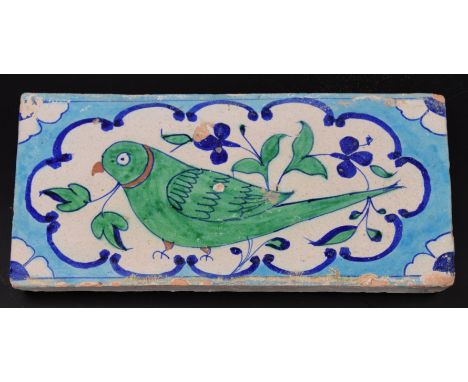 A fine early 19th century North Indian Multan tile depicting a green parrot, 30cm x 15cm
