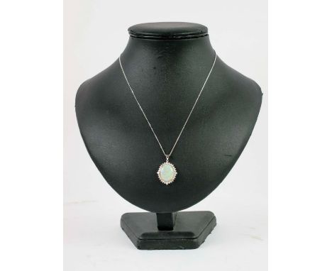 AN 18CT WHITE GOLD OPAL AND DIAMOND PENDANT, the large opal cabouchon of approximately 7.45 carats, surrounded by 28 round br