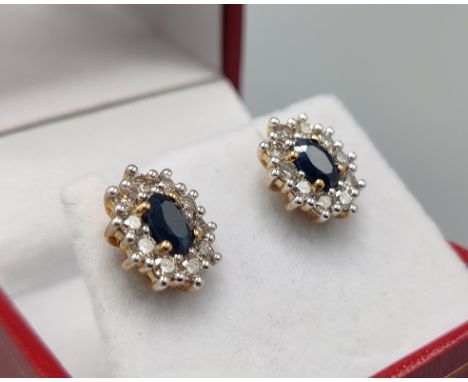 A PAIR OF SAPPHIRE AND DIAMOND STUD EARRINGS, 9ct yellow gold backs, each with a single mixed cut sapphire surrounded by ten 