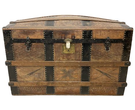 Victorian leather bound travelling trunk, hinged dome top, the outside decorated with etched geometric designs and wrought ir