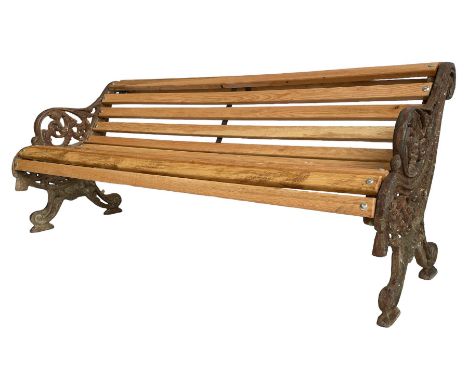 Victorian cast iron and oak slatted garden bench, the bench ends decorated with pierced foliage scrolling and trailing rope, 