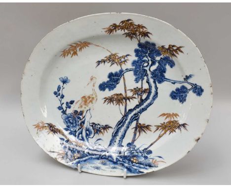 A Chinese Porcelain Platter, 18th Century, painted in underglaze blue, iron red and gilt with a crane beside a pine tree and 