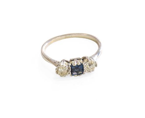 A Sapphire and Diamond Three Stone Ring, the square sapphire flanked by old cut diamonds, in white claw settings, to a tapere