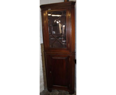 A George III style mahogany corner display cabinet, on stand, the upper section with an astragal glazed door revealing a shel