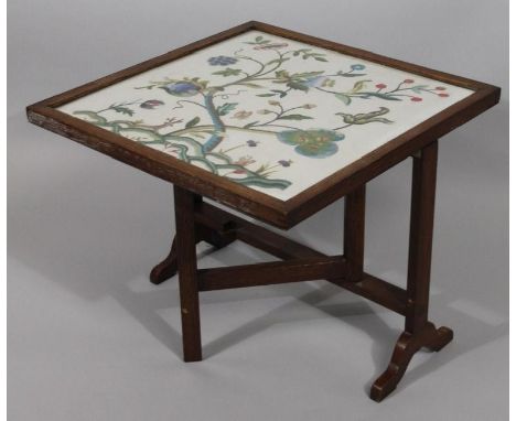 Early to mid 20thC oak firescreen, with articulated top embroidered with birds and flowers, (when open) 69cm high, 59cm wide,