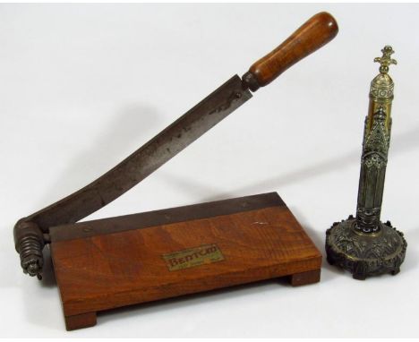 An early 20thC Benton Loughborough wooden and metal paper trimmer, 39cm wide, and a brass ecclesiastical candlestick of highl