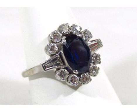 An Art Deco diamond and sapphire cluster ring, with central claw set oval stone of approx 1.19cts, surrounded by ten round br