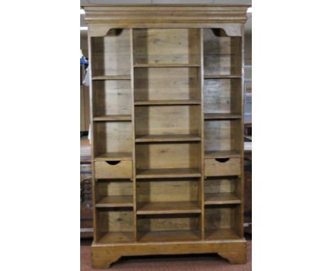 A light oak freestanding open bookcase, with moulded cornice above an arrangement of pigeon holes on a moulded base, 205cm hi