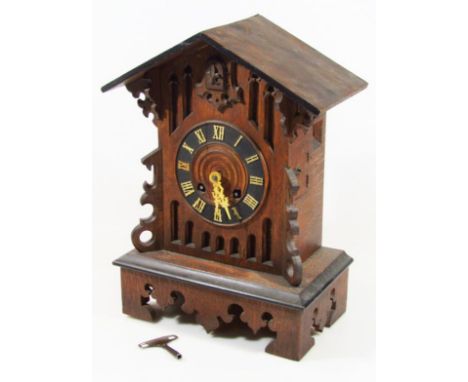 An early 20thC Swiss Black Forest oak mantel cuckoo clock, with 14cm dia. Roman numeric dial, in a heavily carved case reveal
