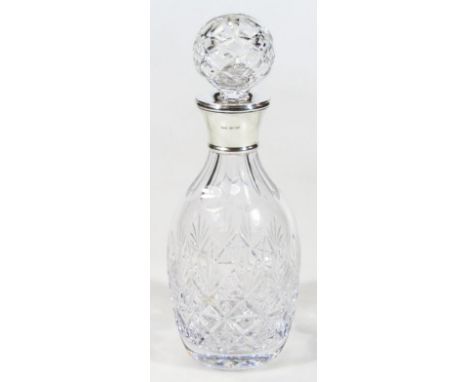 A 20thC cut glass and silver decanter, with orb stopper, the shouldered body heavily decorated with a repeat floral pattern, 