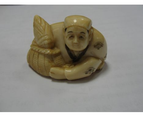 A meiji period netsuke of seated man and basket