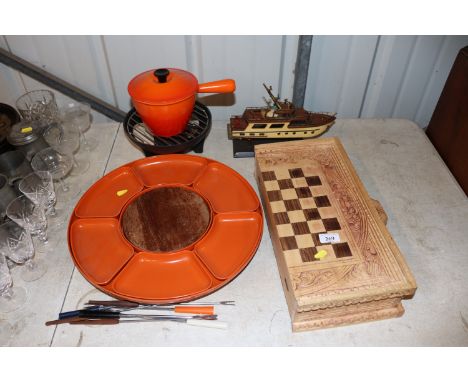 A carved wooden games box; a model of a yacht; a Le Creuset saucepan on heated stand; a Fondue set etc.