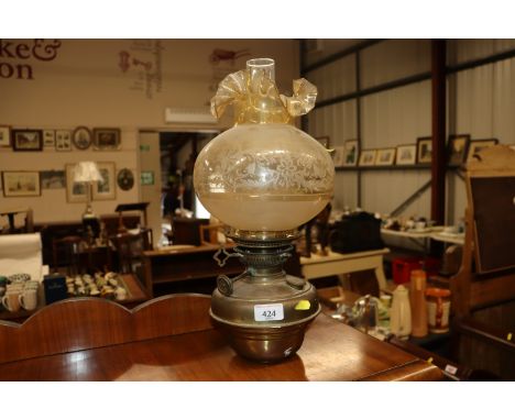 A brass oil lamp with etched glass shade 