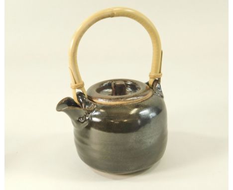 IAN STEELE. A cane handled teapot. Height 22cm. inc. handle. Impressed mark.