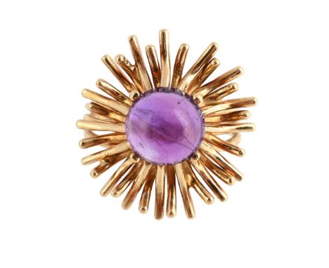 
	
		AN AMETHYST DRESS RING
		The circular cabochon amethyst within a radiating surround of polished rods, to a trifurcated h