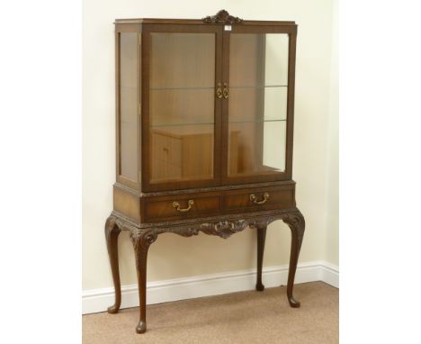 Reproduction mahogany display cabinet enclosed by two glazed doors, fitted with two drawers, carved frieze panel and cabriole