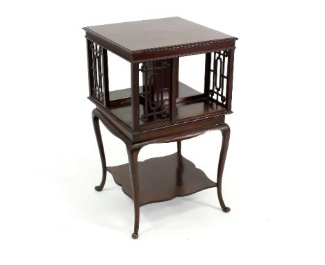 An Edwardian revolving bookcase, the top with four sections, the fretwork compartments on fixed base with single shelf on cab