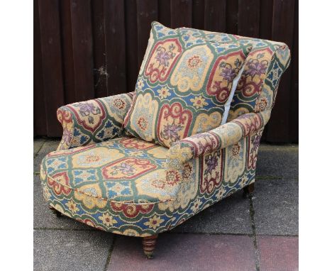 Howard & Sons, an upholstered armchair, model 13717/1284 with scroll back and deep seat on turned front legs with castors   C