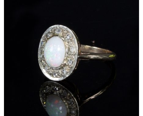 An opal and diamond dress ring, the oval opal cabochon in a surround of ten illusion set diamonds to a 9ct gold band, ring si