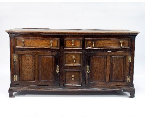 An oak dresser fitted drawers and cupboards, on carved bracket feet, 161cm wide