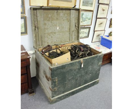 A large trunk containing a quantity of horse rugs and tack