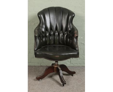 A late 20th century green leather button back swivel desk chair on a swivel base and castors.  