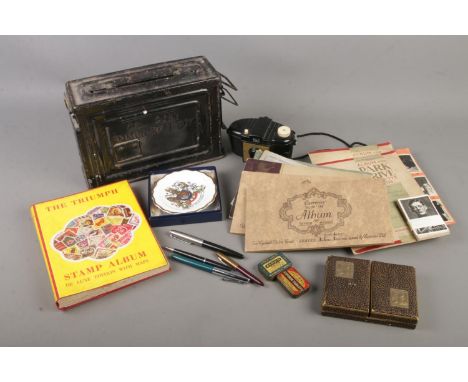 An assorted mix of collectables including cigarette cards, an album of stamps from around the world, Waddington's playing car