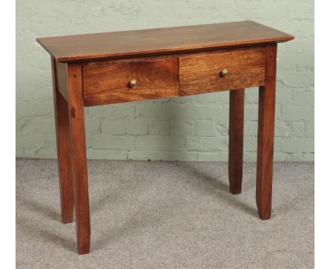 A mahogany two drawer console table featuring tapered supports. Approx. dimensions 94cm x 37.5cm x 80cm.  