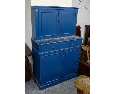 An early 20th century blue painted pine cabinet, two cupboard doors above a pair of short drawers, over a further pair of cup