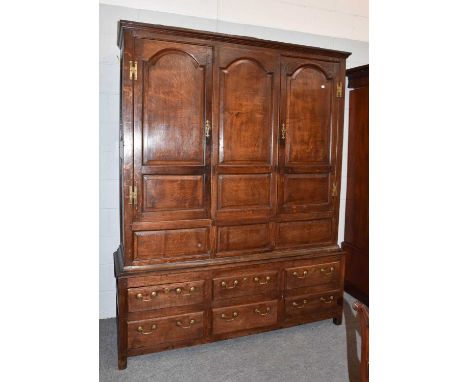 An 18th century joined oak livery cupboard, with three panel doors over a bank of six drawers, 172cm by 54cm by 215cmThe fron