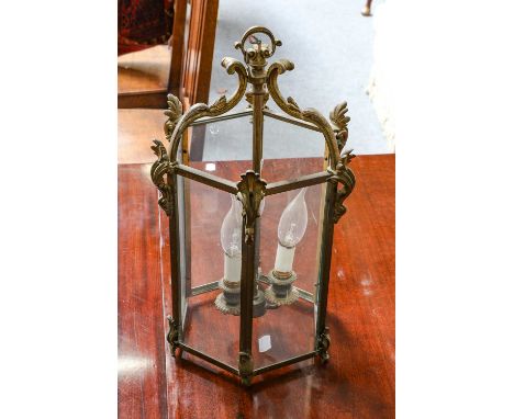 A brass hexagonal three light ceiling lantern with scrolling mounts