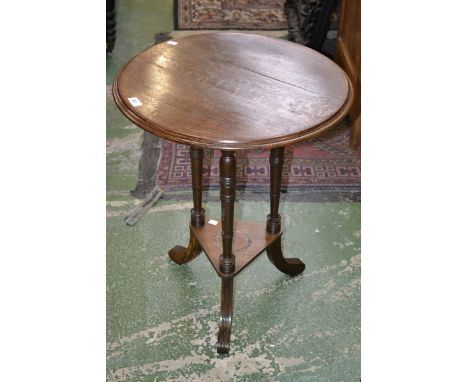 A Victorian oak table on tripod base with shelf