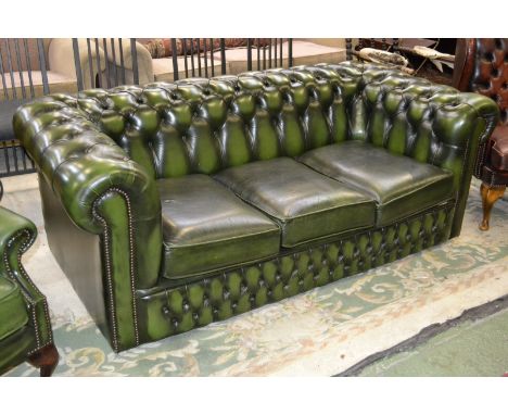 A deep button back green leather three seat Chesterfield sofa