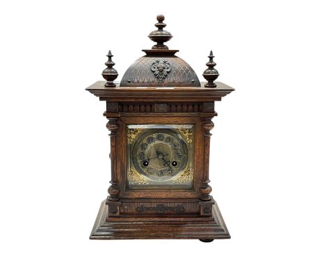 Ornate oak mantel clock with finials and a gilt dial, 43cm high.