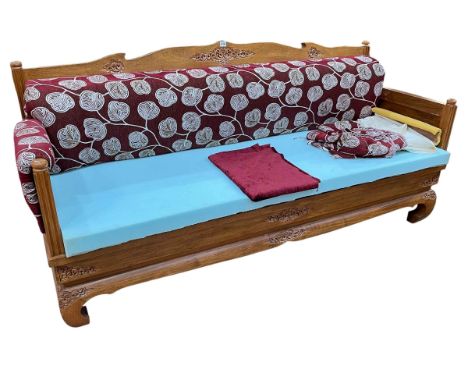 Malaysian carved hardwood bench, the arms and back panel carved externally with tropical forest scenes, 94cm by 191cm by 69cm