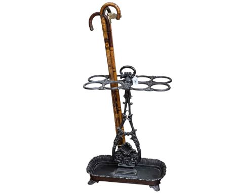Cast iron eight division stick stand, 68cm by 46.5cm by 26cm, together with a collection of four walking canes.