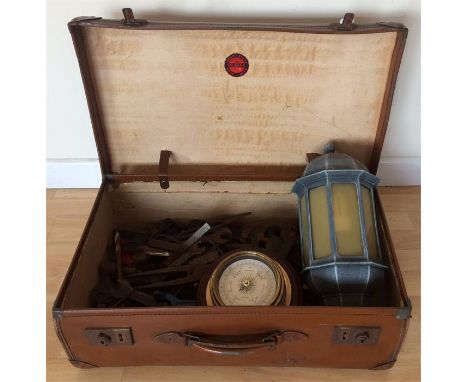 A vintage leather suitcase containing a quantity of vintage hand tools, an outdoor electric light, a barometer, and a McKelle